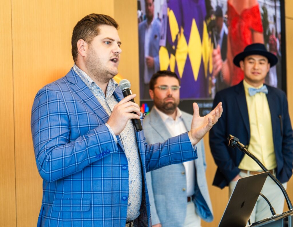 Tyler Hamik, co-founder & chief revenue officer of docology, speaks with a microphone at a podium